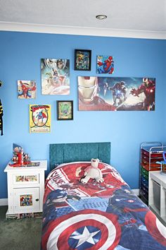 a child's bedroom with captain america bedding and pictures on the wall