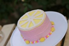 a pink and yellow cake sitting on top of a white plate