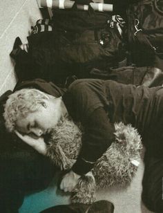 a young boy laying on the floor with his head in his hands and luggage behind him