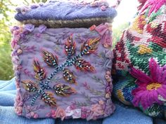 two colorful bags sitting next to each other on top of a person's lap