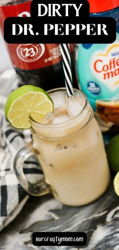 a drink in a mason jar with limes and ice cream on the rim next to it