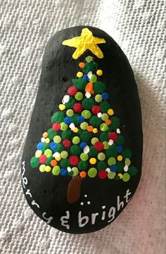 a painted rock with a christmas tree on it