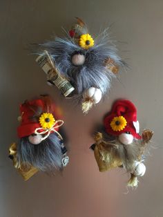 three small stuffed animals with hats and flowers on them