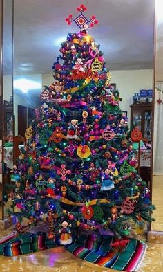 a brightly colored christmas tree in the middle of a room with other decorations on it