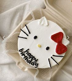 a hello kitty birthday cake with red bow on it