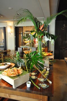 a table filled with lots of food on top of a hard wood floored dining room table