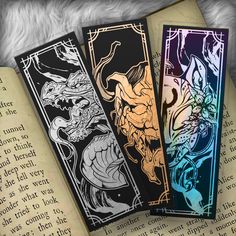 three bookmarks sitting on top of an open book