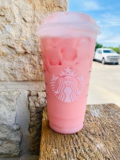 a pink drink sitting on top of a wooden table