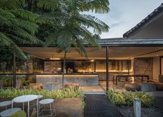 an outdoor kitchen and dining area are shown in this modern style house with stone walls