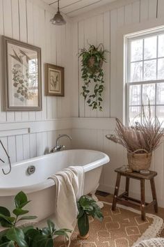 a white bath tub sitting under a window next to a plant filled bathroom floor mat