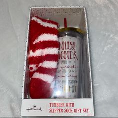 a red and white striped sock sitting in a box next to a tube of toothpaste