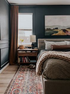 a bedroom with a large bed and a painting on the wall