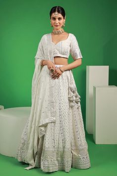 White lehenga with attached can can and mukaish embroidered floral motifs. Comes with padded blouse and dupatta.
Components: 3
Pattern: Embroidered
Type Of Work: Thread, Mukaish
Neckline: V-neck
Sleeve Type: Half
Fabric: Georgette
Color: White
Other Details: 
Attached lining
Lehenga Length: 42 inches
Model Height: 5ft 4inches wearing size S
Closure: 
Lehenga: Side drawstring
Blouse: Back hook
Occasion: Mehendi and Haldi,Sangeet - Aza Fashions White Fitted Pre-draped Saree For Eid, Festive White Pre-draped Saree With Intricate Embroidery, White Anarkali Pre-draped Saree With Intricate Embroidery, White Chikankari Embroidery Gown For Party, White Saree Gown For Navratri, White Wedding Gown With Mirror Work, Designer White Choli With Intricate Embroidery, White Cutdana Gown For Navratri, White Pre-draped Saree With Intricate Embroidery For Festive Occasions