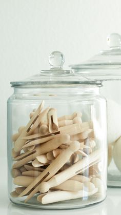 two glass jars filled with wooden dows and an onion