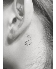 a black and white photo of a woman's ear with a cat tattoo on it