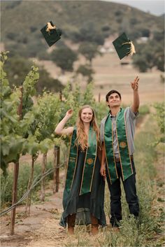 a man and woman in graduation gowns are throwing their hats into the air while standing next to each other