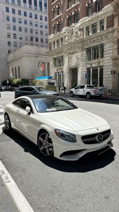 a white car is parked on the street