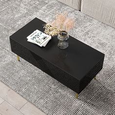 a black coffee table sitting on top of a rug