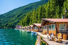 boats are parked on the water near wooden cabins