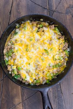 a skillet filled with food sitting on top of a wooden table