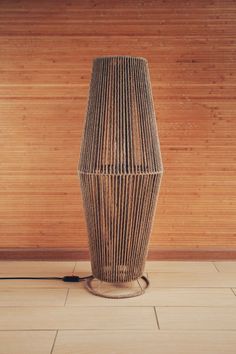 a lamp sitting on top of a tiled floor next to a wooden paneled wall