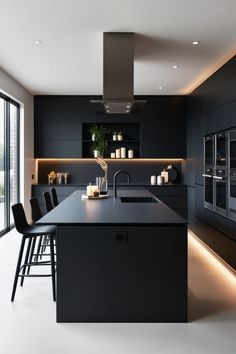 a modern kitchen with black cabinets and counter tops, along with an island in the middle