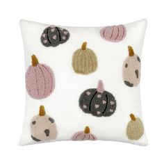 a white pillow with various embroidered pumpkins on it