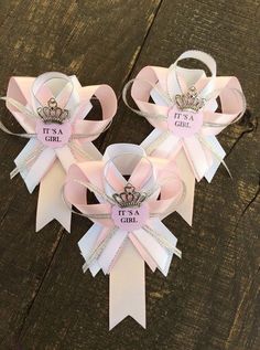 two pink and white bows with tiaras on them sitting next to each other in front of a wooden table