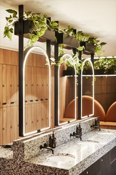 a bathroom with three sinks and mirrors on the wall