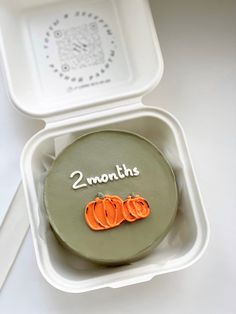 there is a cake with two pumpkins on it in a box that says 2 months