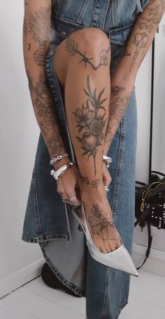 a woman with tattoos on her legs and heels is holding onto the leg of another person