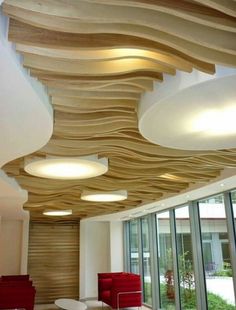 the ceiling is made out of wood and has round lights above it, along with red chairs