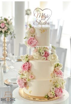 a three tiered wedding cake with pink and white flowers