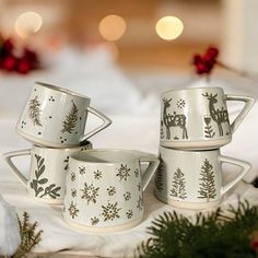 three white christmas mugs sitting on top of a table