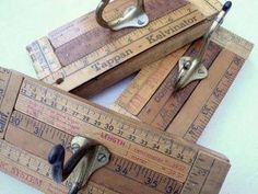 three wooden rulers with metal handles on top of each other and measuring tape in the middle