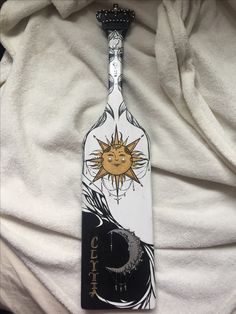 a white tie with an image of a sun and moon on it sitting on top of a towel