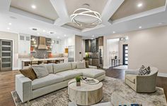 a living room filled with furniture next to a kitchen