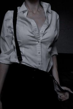 black and white photograph of a woman with suspenders on her chest wearing a shirt