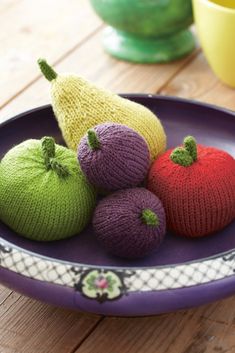 three knitted fruits are on a plate