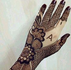 a woman's hand with henna tattoos on it