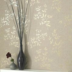 two vases with flowers on a shelf in front of a wallpapered background