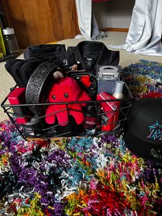 a basket filled with items sitting on top of a colorful rug next to a hat