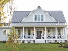 a white house sitting on top of a lush green field