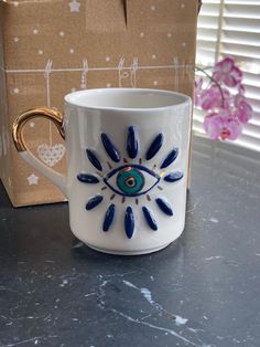 a coffee cup with an evil eye painted on it