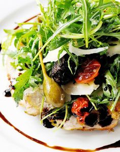 a white plate topped with salad and olives