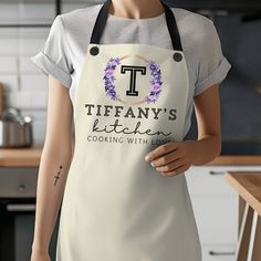 a mannequin wearing an apron with the words tiffany's kitchen on it