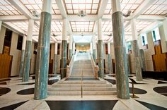 the inside of a building with marble floors and stairs leading up to an elevator area