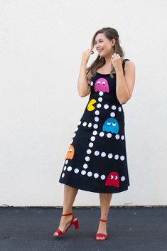 a woman in a black dress is talking on her cell phone while standing next to a white wall