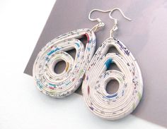 the earrings are made out of paper and have colorful designs on them, as if they were