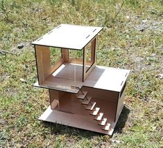 a cardboard doll house with stairs in the grass